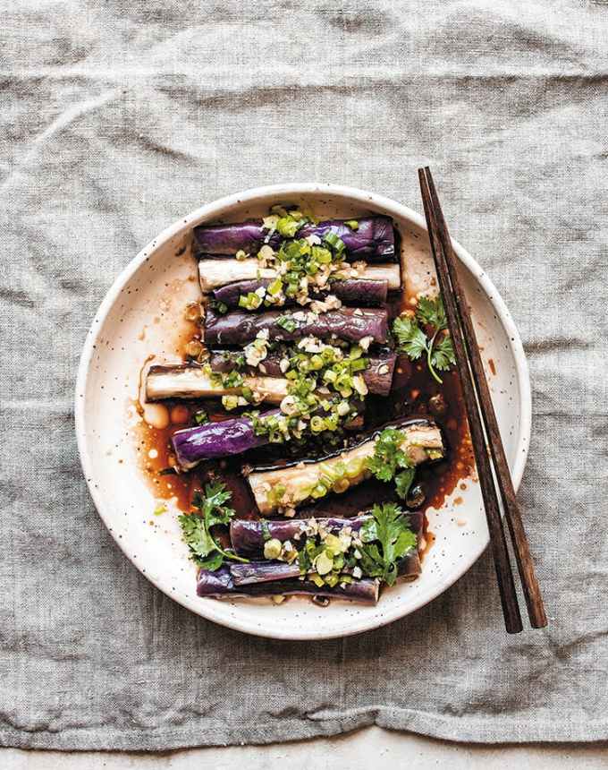 traditional chinese new year foods: seasoned steamed eggplant on a plate with chopsticks