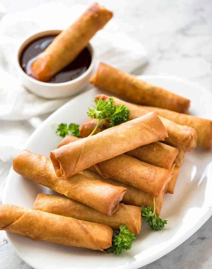 traditional chinese new year foods: a serving platter of spring rolls with dipping sauce