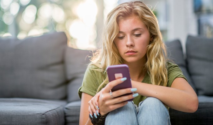 what to text after being ghosted: hey, are you ok? white woman looks dejectedly at phone