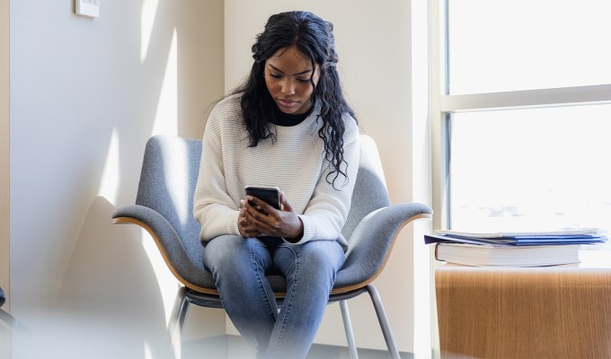 what to text after being ghosted: There’s no way we won’t run into each other. Please give me space. black woman sitting in a chair looks down at phone